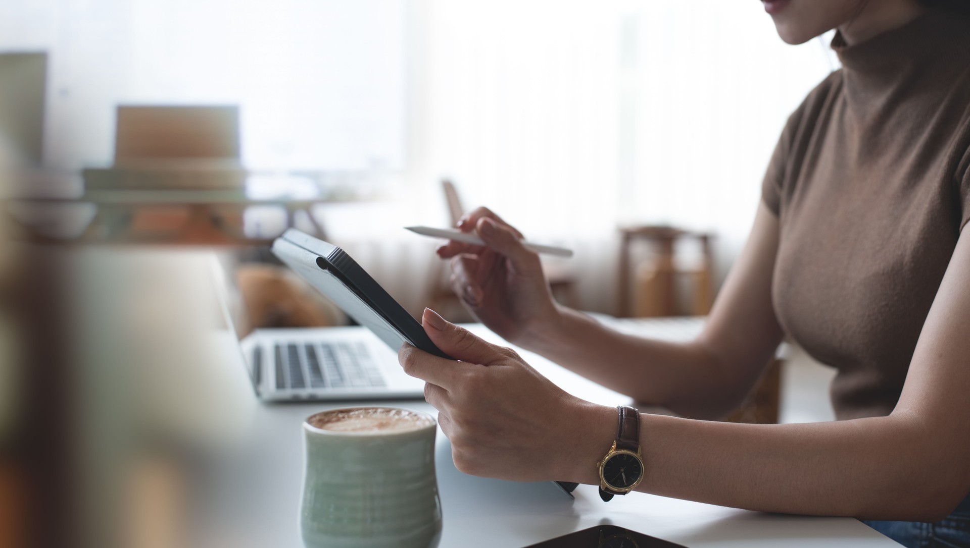 Casual business woman using digital tablet, working in coffee shop with laptop computer on table. Freelancer, organizer online working in office, planning event schedule on digital tablet